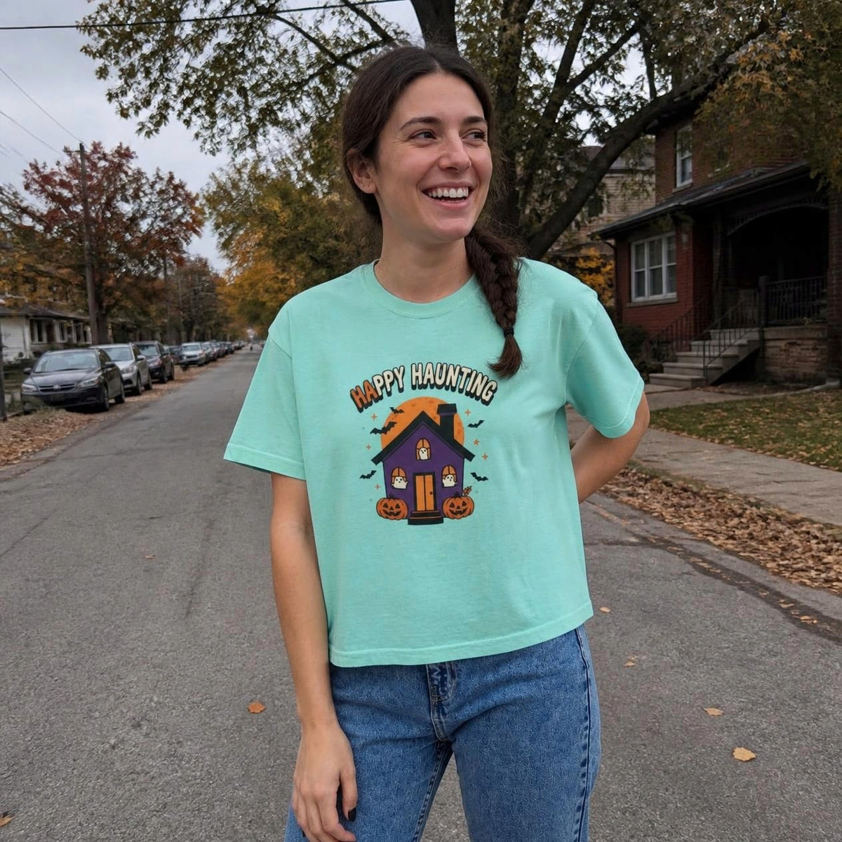 Woman wearing the chalky mint Happy Haunting Haunted House boxy crop tee, lifestyle photo (Color: Chalky Mint)