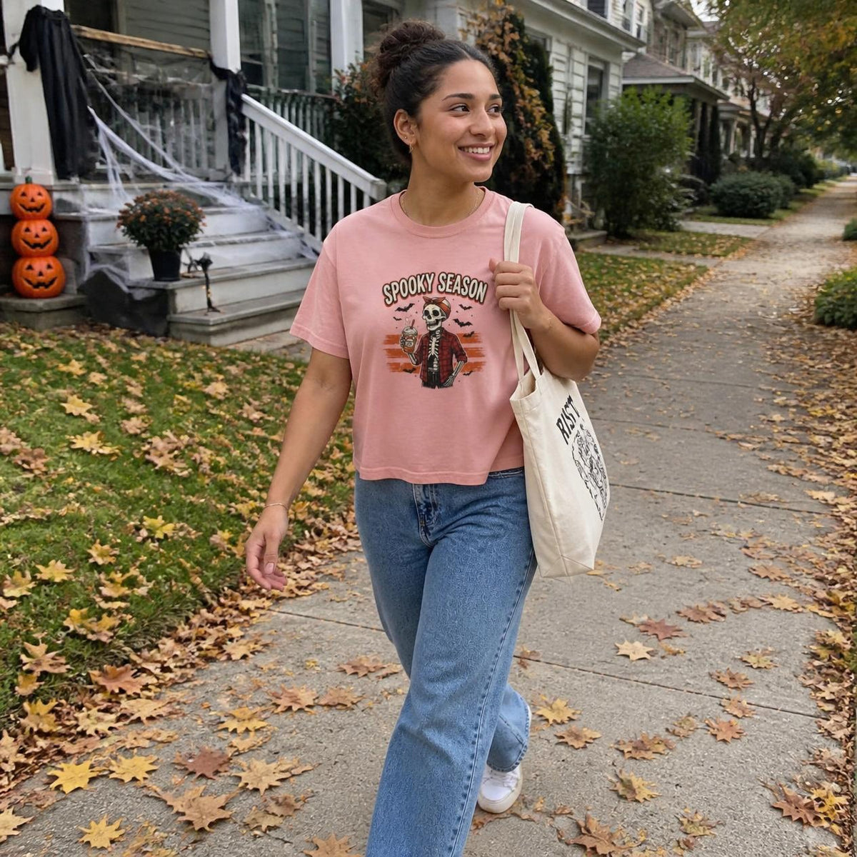 Woman wearing the peachy Spooky Season Skeleton boxy crop tee, lifestyle photo (Color: Peachy)
