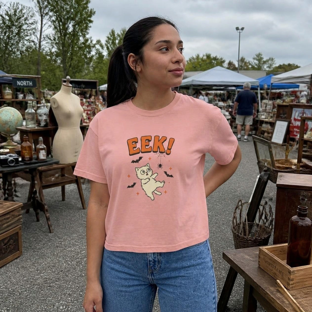 Woman wearing the peachy Eek! Scared Cat boxy crop tee, lifestyle photo (Color: Peachy)