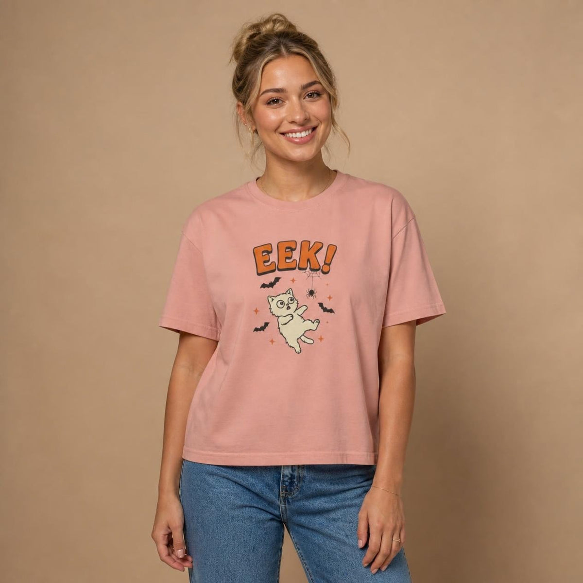 Model wearing the peachy Eek! Scared Cat boxy crop tee, studio photo (Color: Peachy)