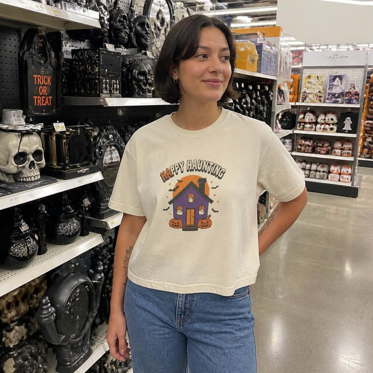 Woman wearing the ivory Happy Haunting Haunted House boxy crop tee, lifestyle photo (Color: Ivory)