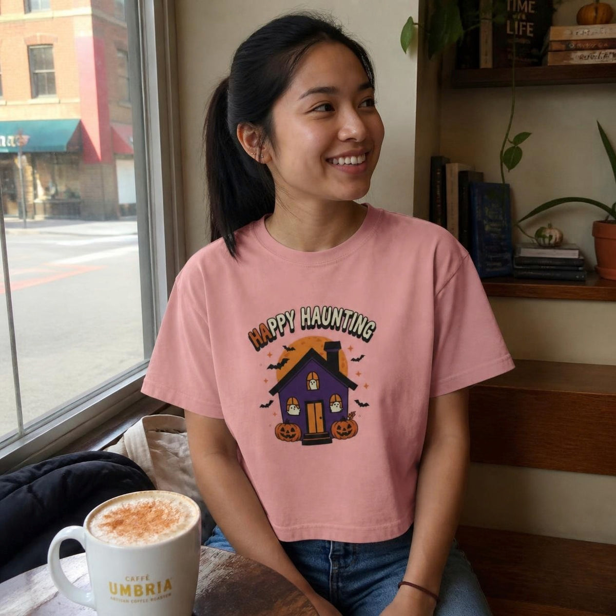 Woman wearing the peachy Happy Haunting Haunted House boxy crop tee, lifestyle photo (Color: Peachy)