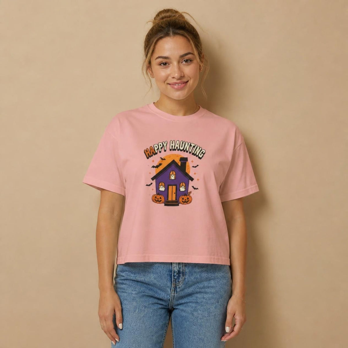 Model wearing the peachy Happy Haunting Haunted House boxy crop tee, studio photo (Color: Peachy)