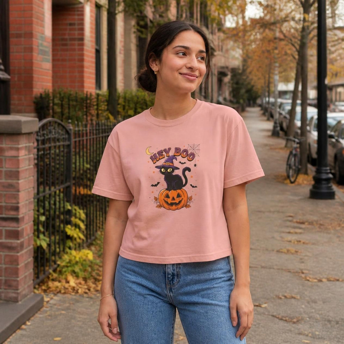 Woman wearing the peachy Hey Boo Black Cat boxy crop tee, lifestyle photo (Color: Peachy)
