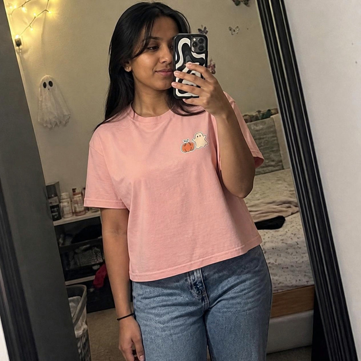 Woman wearing the peachy Pumpkin Ghost boxy crop tee, lifestyle photo (Color: Peachy)