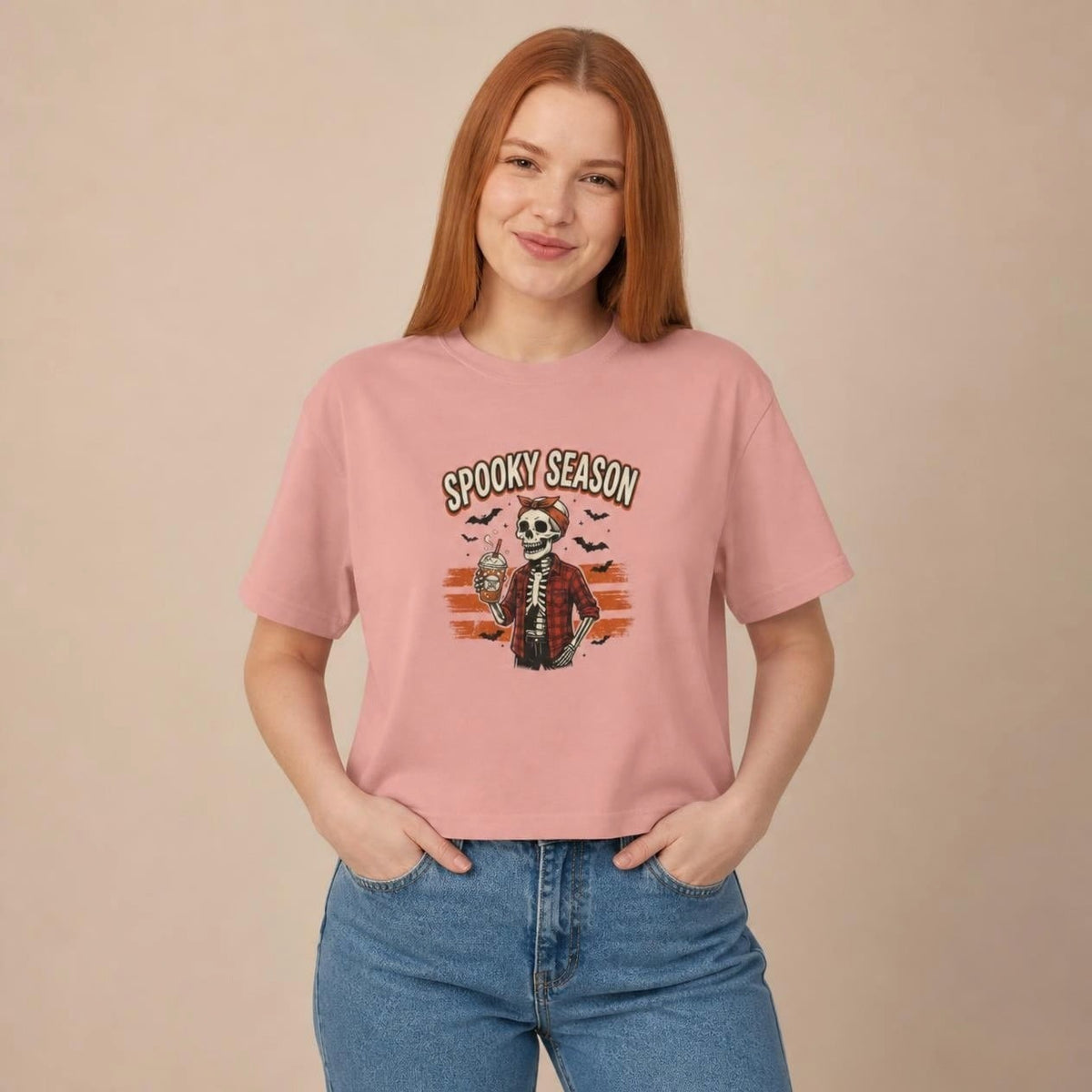 Model wearing the peachy Spooky Season Skeleton boxy crop tee, studio photo (Color: Peachy)