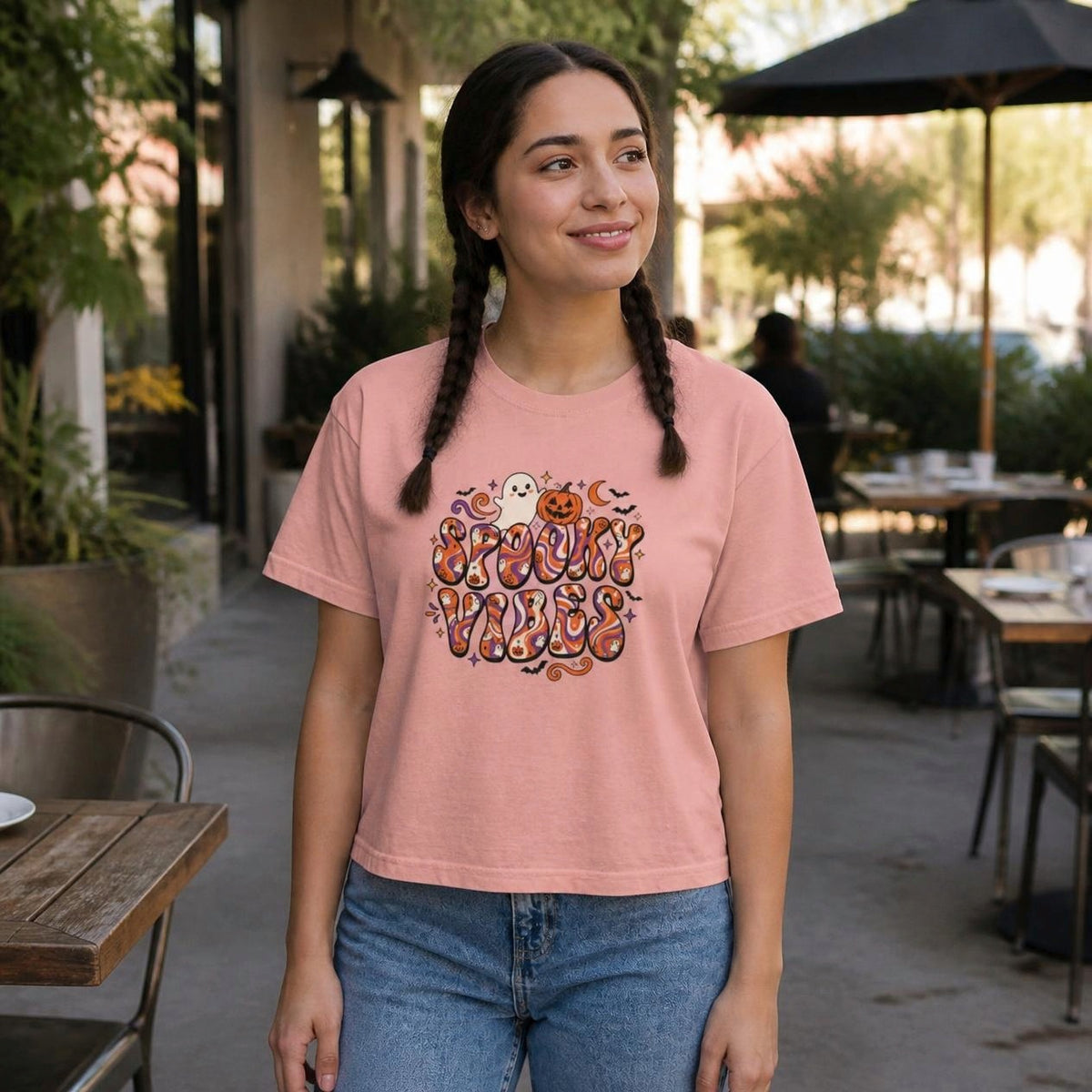 Woman wearing the peachy Spooky Vibes Retro boxy crop tee, lifestyle photo (Color: Peachy)